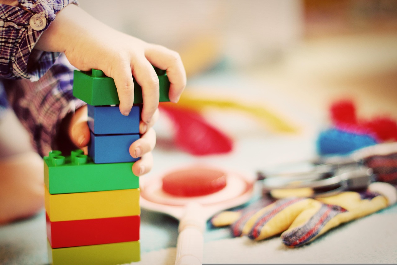 kid's hands playing with duplo blocks. 